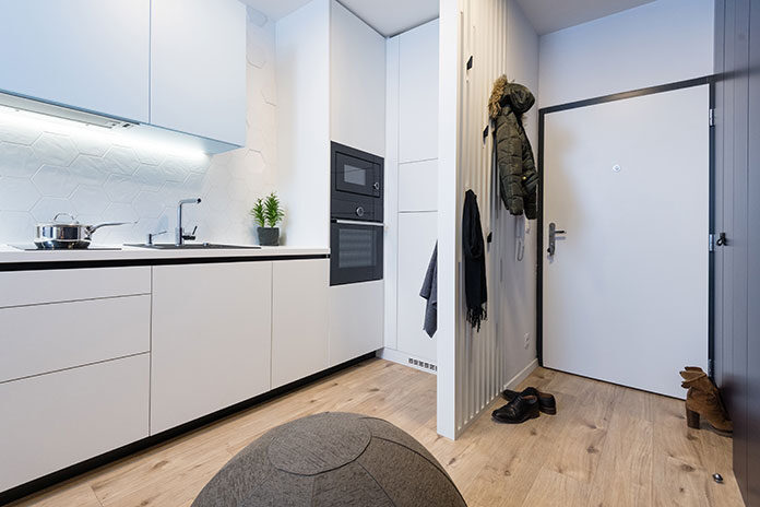 Drzwi wejściowe do mieszkania w bloku – widok na przedpokój i aneks kuchenny